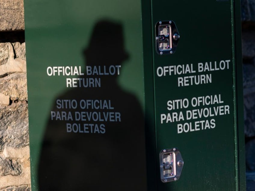 PHILADELPHIA, PA - OCTOBER 17: A pedestrian casts a shadow on an early voting ballot at dr