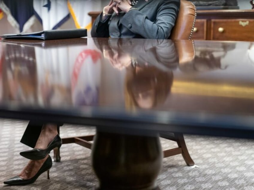 Vice President Kamala Harris’s reflection is seen in the table of the Roosevelt Room of