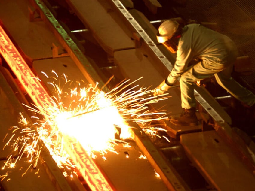 A worker cuts through a glowing 2,000 degrees Fahrenheit "billet" at the TAMCO s