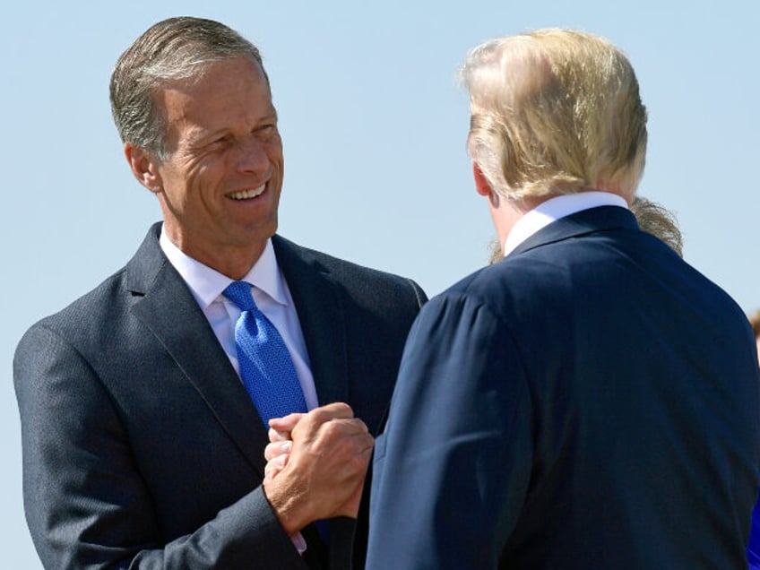 President Donald Trump, right, is greeted by Sen. John Thune, R-S.D., left, after arriving