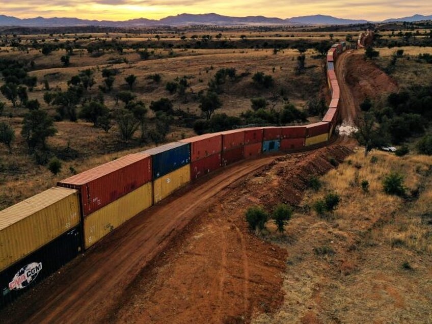 TOPSHOT - An aerial image shows a border wall constructed of shipping containers and topped with concertina wire built on federal land by Republican governor Doug Ducey, along the US-Mexico border in the Coronado National Forest near Hereford, Arizona on December 20, 2022. - Arizona agreed Wednesday to dismantle a …