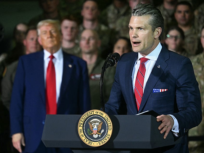 US Secretary of Defence, Pete Hegseth, speaks as US President Donald Trump (L) looks on du