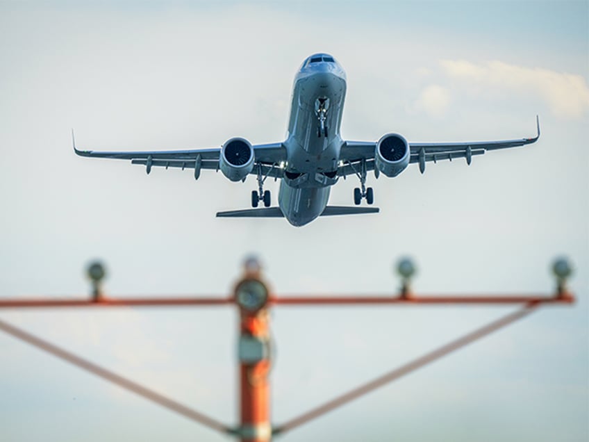 ARLINGTON, VA - AUGUST 12: A passenger jet takes off over the runway threshold lights at R