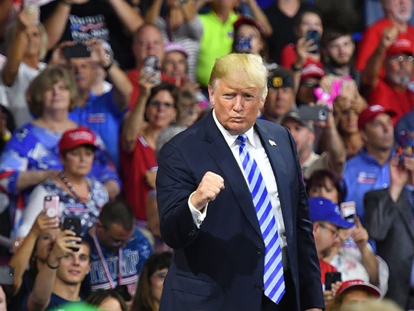 TOPSHOT - US President Donald Trump salutes his supporters after speaking at a political r