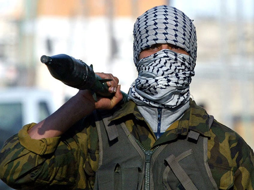 A member of the militant Fateh movement walks along the street January 15, 2005 in Gaza City, Gaza Strip. According to reports, Israel Defense Forces troops killed six Palestinians from the Netzarim settlement and another four from the outskirts of the southern Gaza City neighborhood of Zeitun. (Photo by Ahmad …