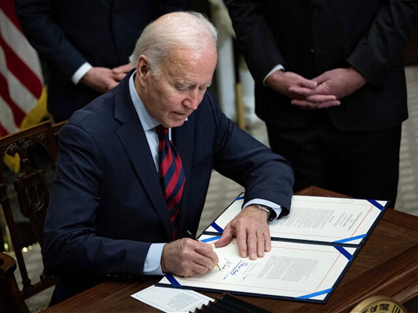 US President Joe Biden signs a resolution to avert a nationwide rail shutdown, in the Roos