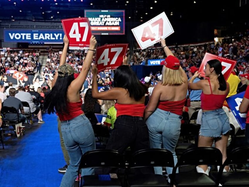 Young women do the YMCA dance during a campaign rally for Republican presidential nominee