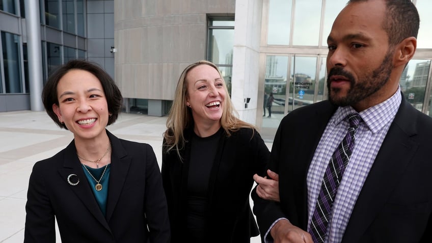 Kirstin Lobato smiles widely outside of the Lloyd George U.S. Courthouse in Las Vegas with her attorneys Elizabeth Wang and David Owens.