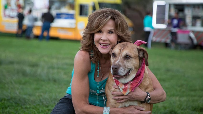 Linda Blair hugging a dog