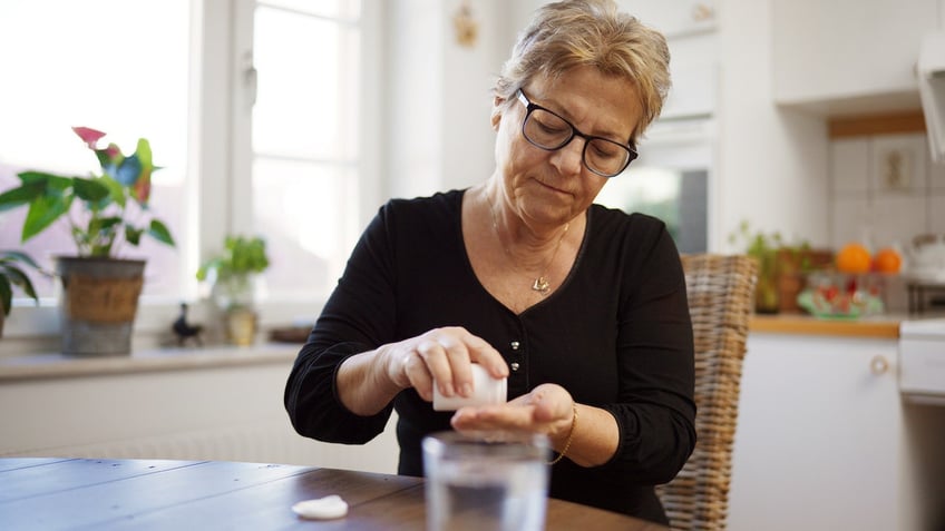 Older woman taking pills
