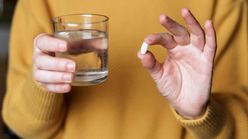 Woman holding pill