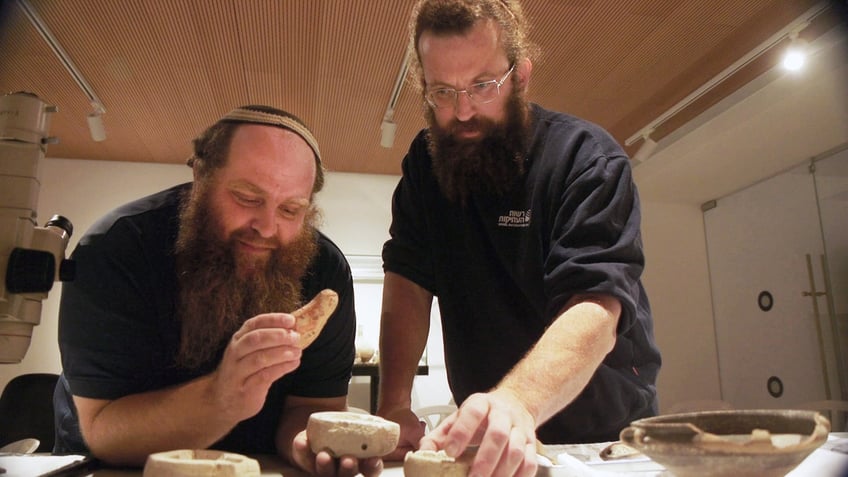 Two men inspecting oil lamp