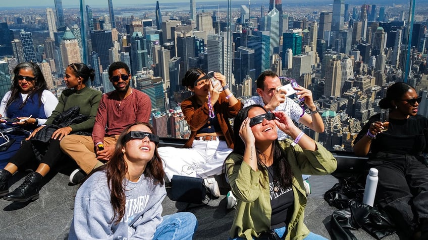 People look toward the sky at the 'Edge at Hudson Yards' observation deck ahead of a total solar eclipse