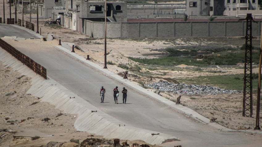 Displaced Palestinians fleeing Gaza City walk along the Israeli army corridor in the Netzarim area in central Gaza, on July 10, 2024.