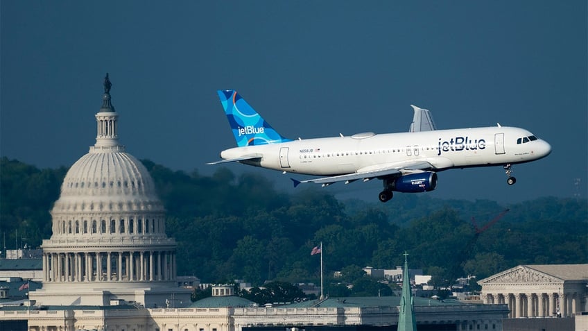 JetBlue Airlines Airbus A320 flies out of Reagan National Airport with the U.S. Capitol in the background