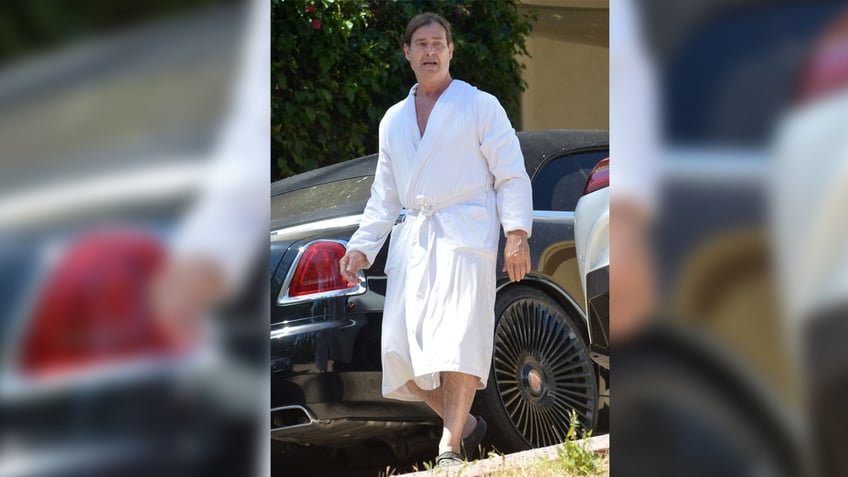 Fabio tied back his blonde hair and wore a bathrobe outside.