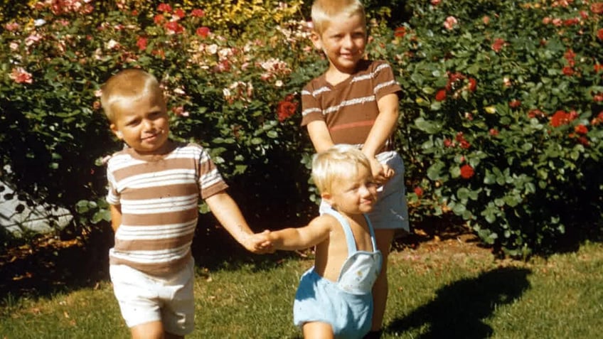 The Hadden brothers holding hands and playing.