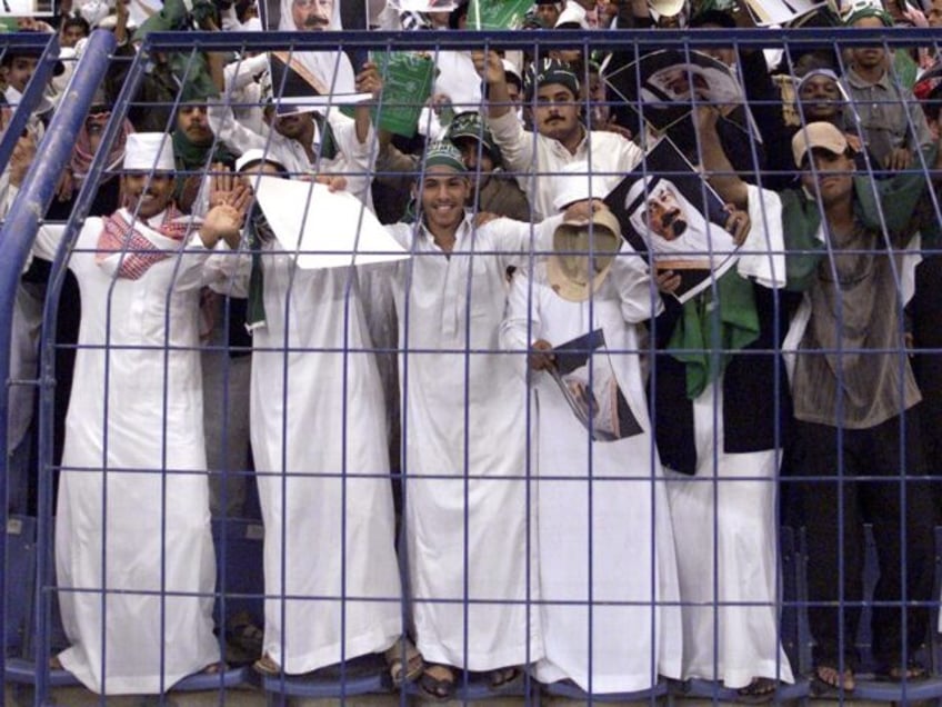Saudi supporters wave pictures of King Fahd and of Crown Prince Abdullah during the final