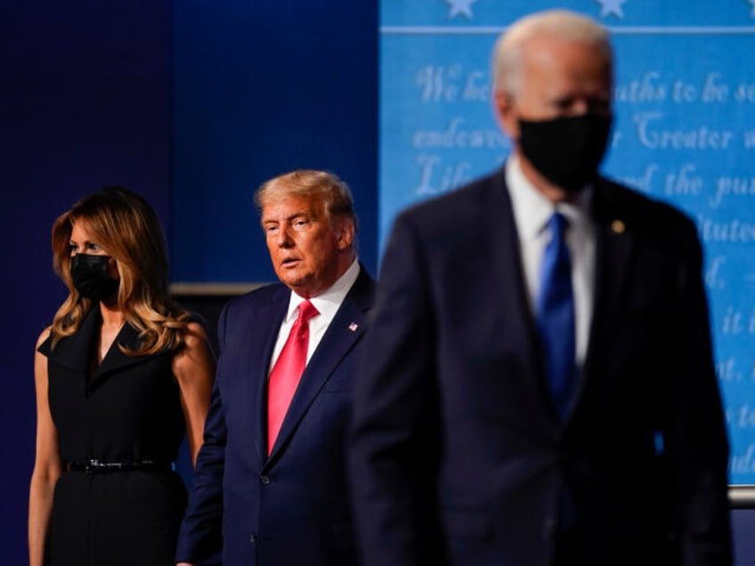 First lady Melania Trump, left, and President Donald Trump, center, remain on stage as Dem