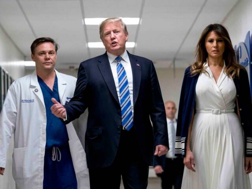 President Donald Trump, center, accompanied by first lady Melania Trump, right, and Dr. Ig