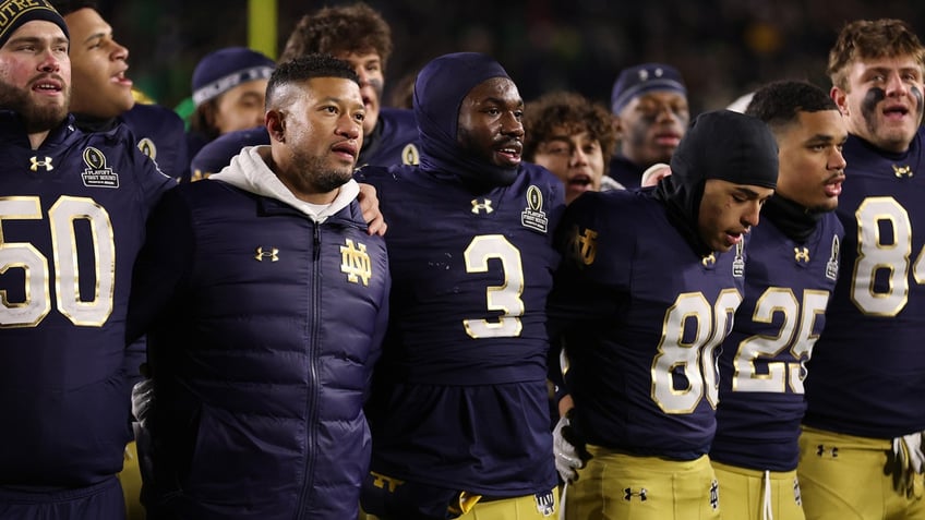 Notre Dame football coach Marcus Freeman celebrates with his players after their home playoff win against Indiana.