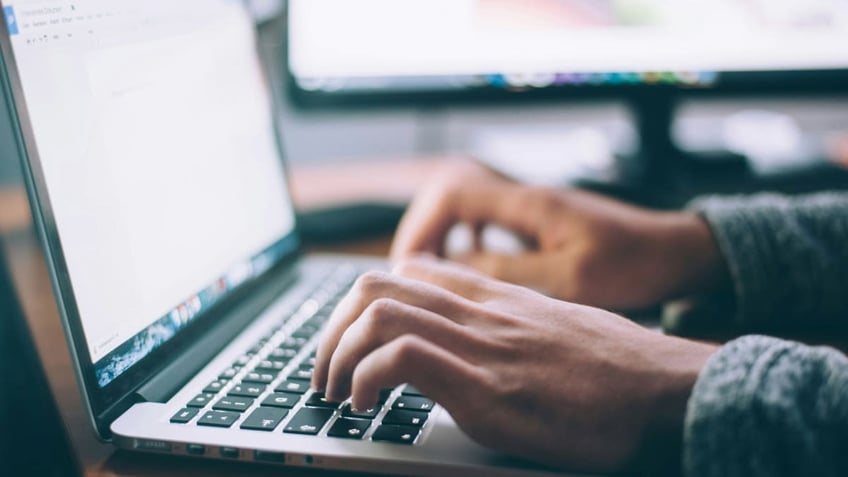 person typing on laptop