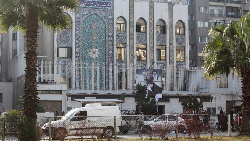 Rebel fighters stand near the Iranian embassy with a torn poster of Hezbollah leader Sayyed Hassan Nasrallah and late Iran's Revolutionary Guards' top commander Qassem Soleimani after Syrian rebels announced that they have ousted President Bashar al-Assad, in Damascus, Syria, Dec. 8, 2024.