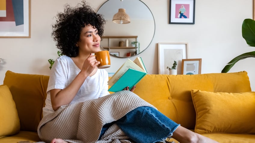 A woman with a cup of coffee and a book