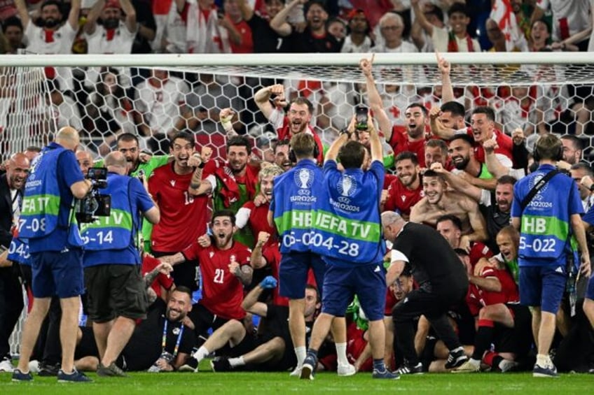 Georgia's players celebrate after qualifying for the last 16 of Euro 2024