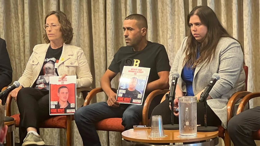 Family members of hostages hold up pictures of their loved ones