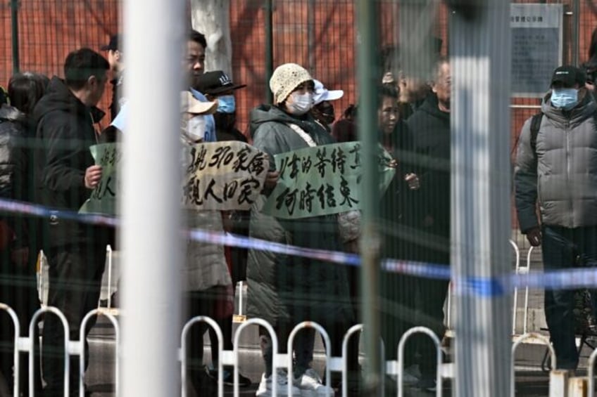 Relatives of Chinese passengers lost on flight MH370 demonstrate outside the Malaysian emb