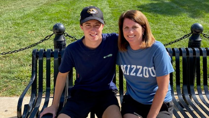 Mary Pat Santulli sitting next to her son Danny Santulli outdoors and smiling.