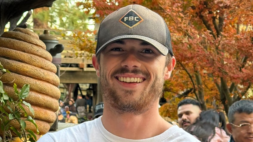 Tyler Thompson, 21, of West Jordan, Utah, wears a grey baseball cap and a white, long sleeve graphic t-shirt.