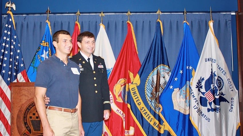 Quest father and son in front of flags