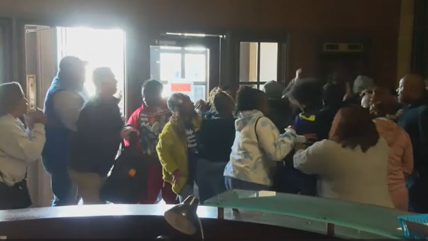 People fighting inside a courthouse with each other and police