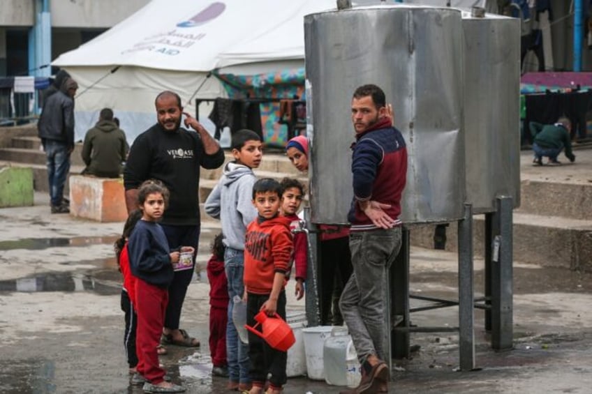 People collect water in the Maghazi camp for Palestinian refugees in the central Gaza Stri