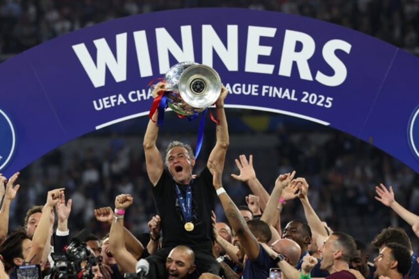 Paris Saint-Germain coach Luis Enrique lifts the Champions League trophy after his side ou