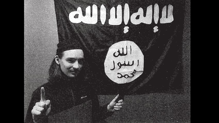 Alexander Mercurio in front of ISIS flag