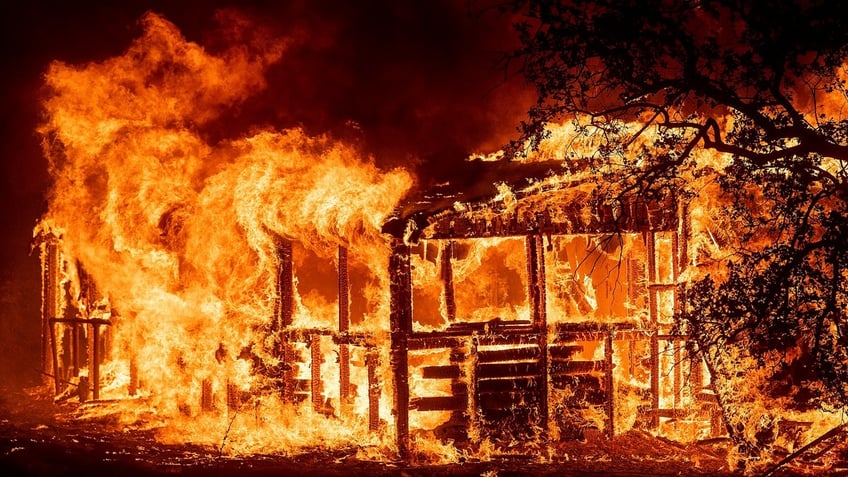 A structure burns as the Carr Fire races along Highway 299 near Redding, Calif., on Thursday, July 26, 2018. (AP Photo/Noah Berger)