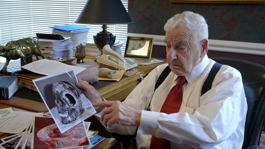 An investigator holds a photo of Sister Cathy Cesnik's skull