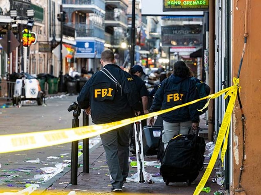 FBI investigators arrive at the scene where the white Ford F-150 pickup truck that crashed