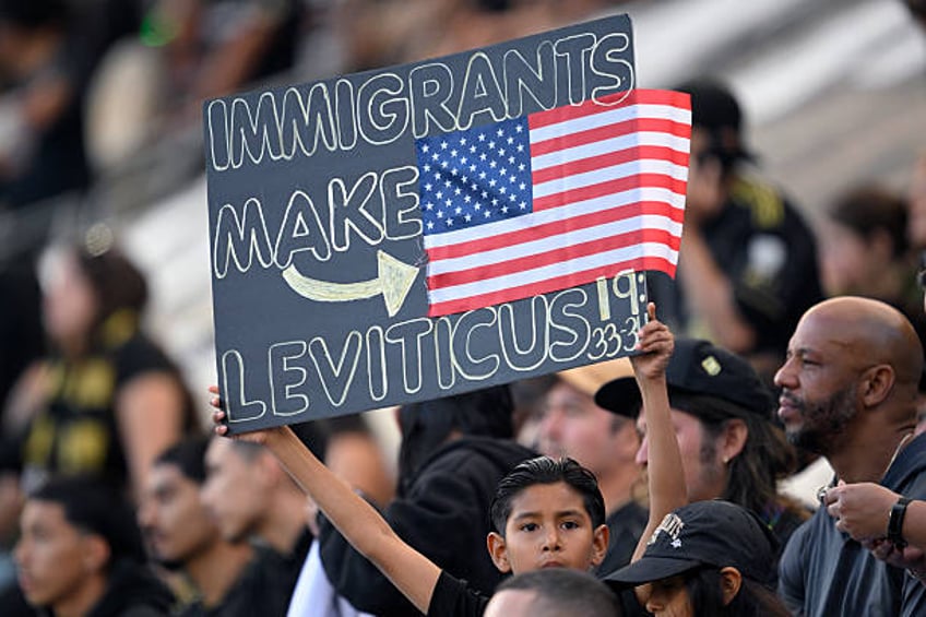 Fan holds up a protest sign in the stands during the first half of the game between Sporting Kansas City and Los Angeles FC at BMO Stadium on June...