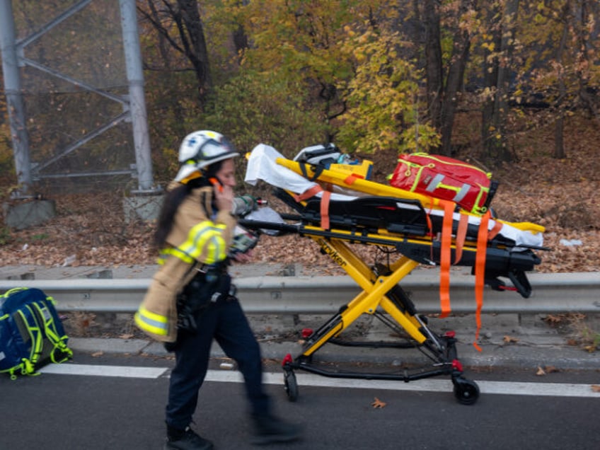 FDNY paramedics wait as firefighters try to extinguish a fast-moving brush fire along Harl