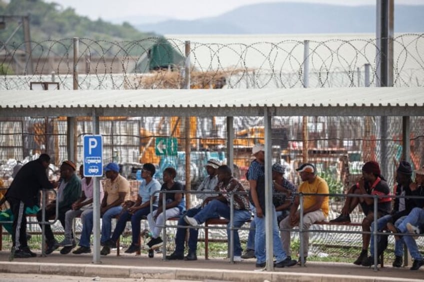 Workers wait at the surface for news of more than 2,000 miners occupying the Impala Bafokeng platinum mine since Monday