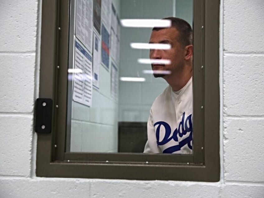 ADELANTO, CA - NOVEMBER 15: An immigrant waits in a processing cell at the Adelanto Detent