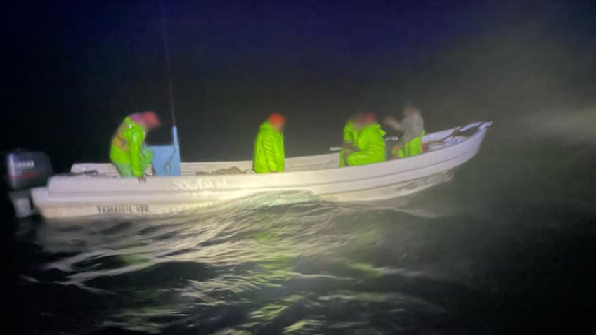 Wide shot of men standing on boat in water