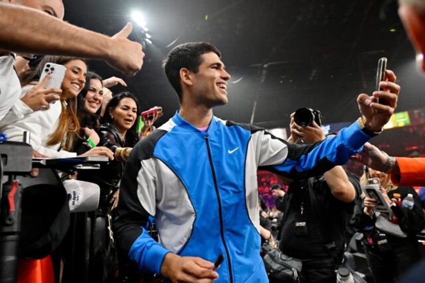 Spain's Carlos Alcaraz takes selfies with fans after winning an exhibition match against R