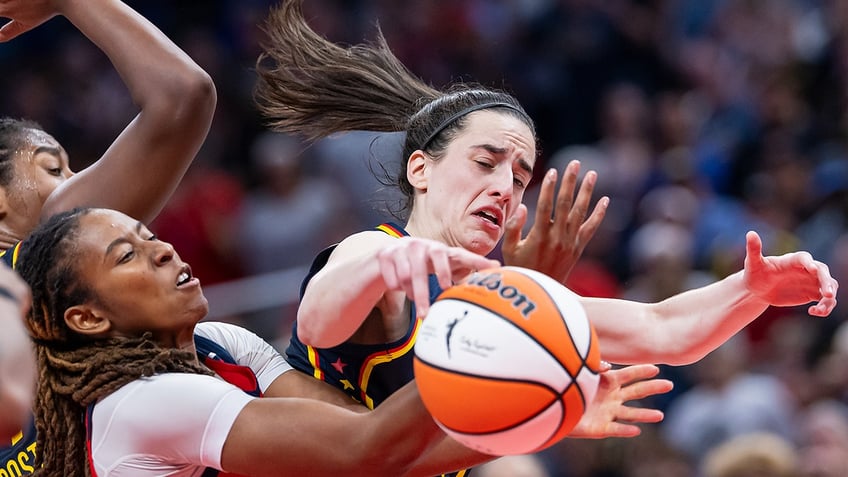 Ariel Atkins and Caitlin Clark try to get a rebound