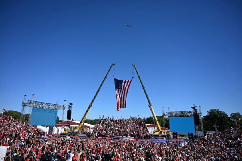 Former president Donald Trump's plane, known as Trump Force One, flies over the crowd ahea