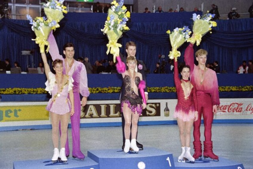 Evgenia Shishkova and Vadim Naumov of Russia (centre) on top of the podium after winning p